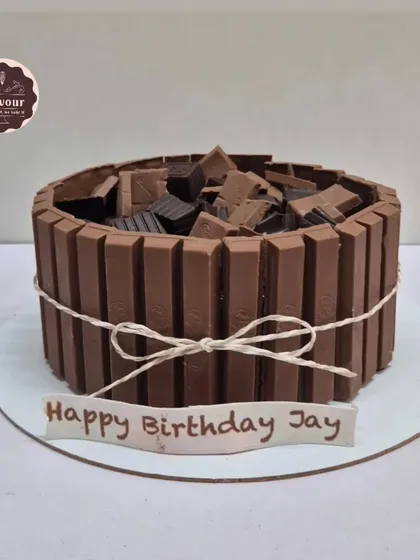 A classic Kit Kat cake. The sides are lined with Kit Kat bars, and the top is filled with chopped chocolate, making it a crunchy, chocolatey dream.