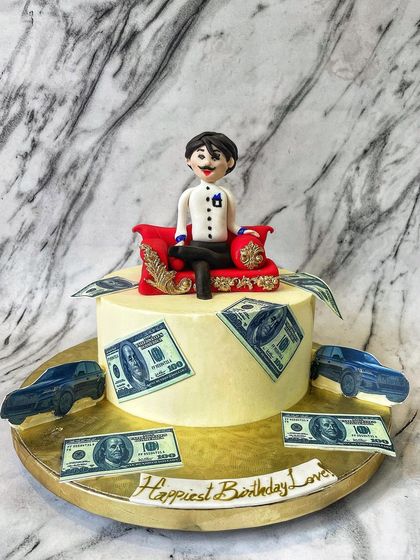 This fun "billionaire" cake features a custom fondant figure sitting on a throne, surrounded by edible money and cars. It's a playful cake for someone who dreams big.