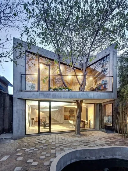 This modern home was designed to fully embrace the tree growing through its center. The large glass windows and open courtyard design make the tree a focal point from both inside and out, showcasing a perfect blend of nature and architecture.