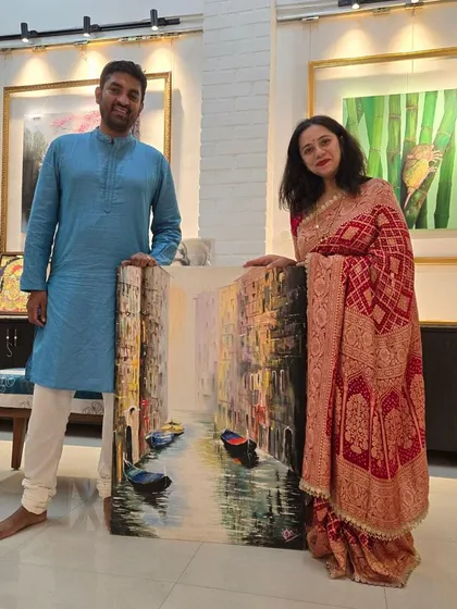 A happy couple of art collectors proudly holds their newly acquired painting of a Venice canal, a testament to the joy and satisfaction of finding the perfect piece at our gallery.