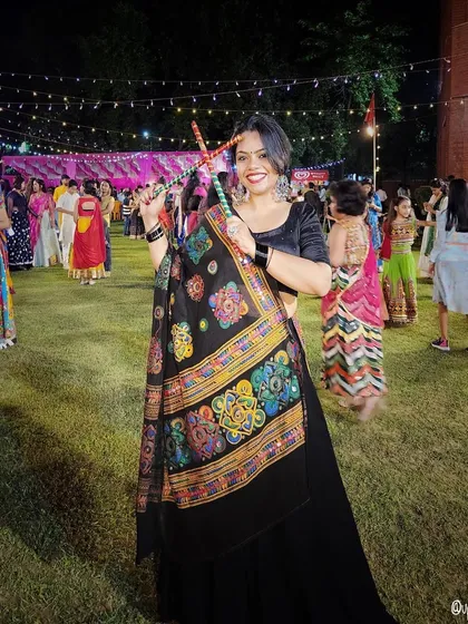 In the spirit of Navratri, this black lehenga with a colorful, embroidered dupatta is perfect for dancing the night away. It's all about vibrant energy and festive fun.