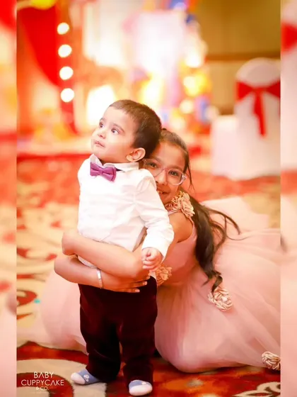 A protective and loving hug from a big sister to her little brother. Sibling photos are a special part of our family event coverage.