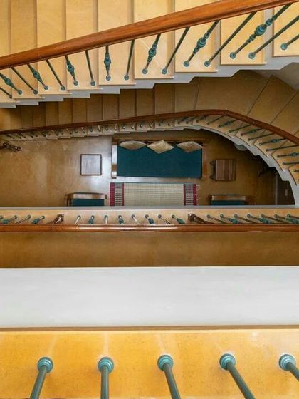 A gracefully curving staircase creates a dramatic vertical space within the home. Viewed from the top, it reveals how open planning connects multiple levels, with natural light from above illuminating the entire core of the house.