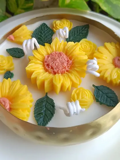 A top-down view of the sunflower urli candle, highlighting the arrangement of the flowers.