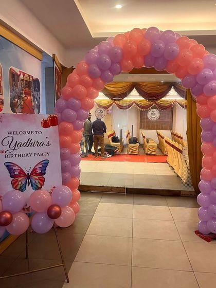 A welcoming entrance for a butterfly-themed birthday party. The pastel pink and purple balloon arch and personalized welcome sign set a beautiful tone for the event.