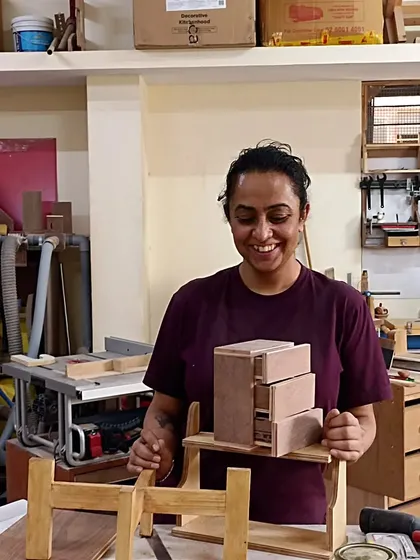 Ritu with the mini chest of drawers she designed and built. This is a more advanced project that involves creating and fitting multiple small drawers into a single carcass.