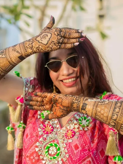 The best feeling is seeing a happy bride enjoying her mehendi. This shot captures the fun and excitement of a wedding celebration, with the intricate henna design being a central part of her look.