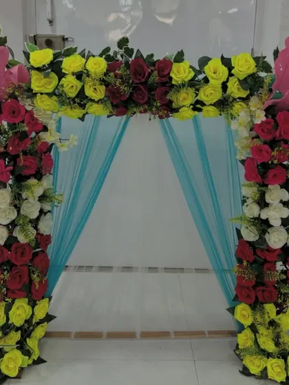 A vibrant and playful floral arch, this piece uses a bright color palette to create a fun and festive atmosphere.