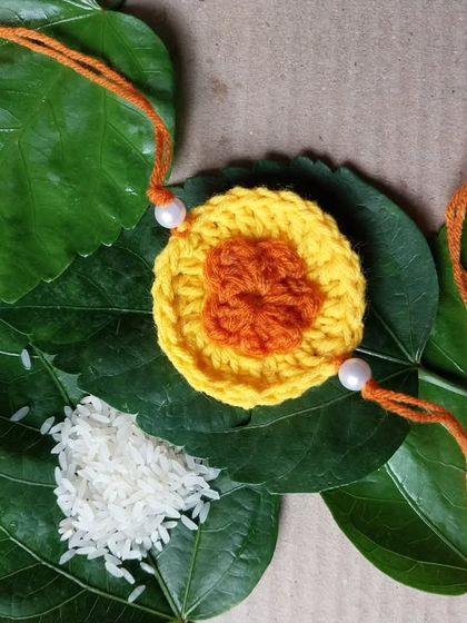 A two-toned circular rakhi, perfect for a simple and elegant look.