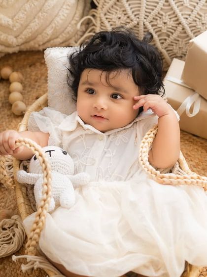A beautiful six-month milestone session with a Boho theme, featuring macrame pillows, sunflowers, and a sweet baby girl in a wicker bassinet.
