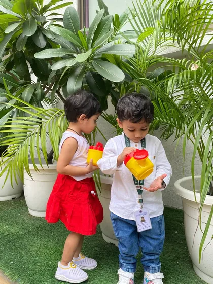 Two little friends work together to water the plants. We encourage collaborative activities that help children learn to share, cooperate, and respect the environment.
