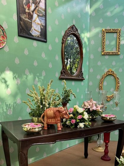A corner of the room showing the thoughtful arrangement of antique furniture, mirrors, and floral elements.
