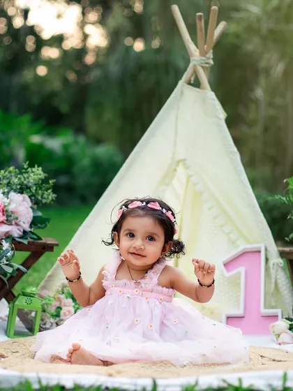 A princess in her teepee tent. This outdoor garden setup for a first birthday is whimsical, beautiful, and perfect for a sunny day celebration.