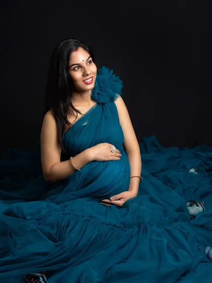 Surrounded by the flowing fabric of her gown, this pose creates a sense of being enveloped in a soft, dreamy cloud. It’s a beautiful way to highlight the baby bump.