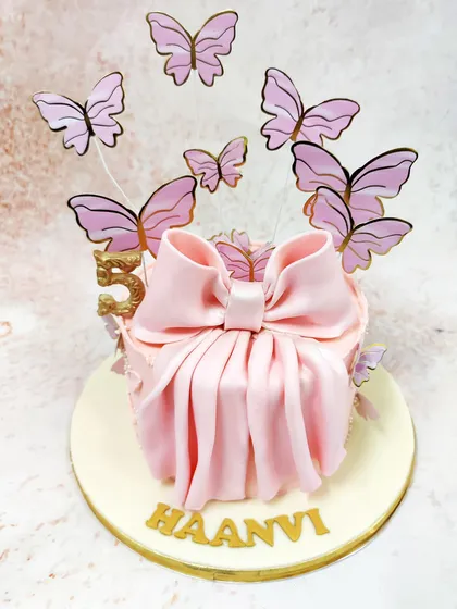 Another view of the butterfly bow cake, highlighting the graceful pleats of the bow and the shimmering gold accents.