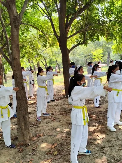 Yellow belt students practicing a fundamental block in unison during a technical seminar. Correct arm position and stance are critical.