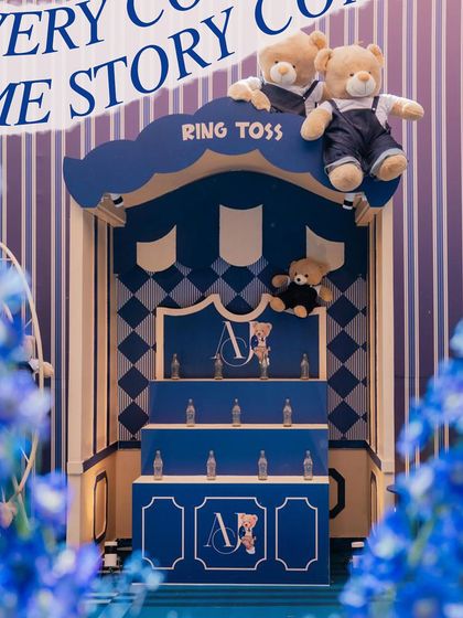 A themed ring toss game booth, complete with teddy bears cheering on the players, seamlessly integrated into the party's design.