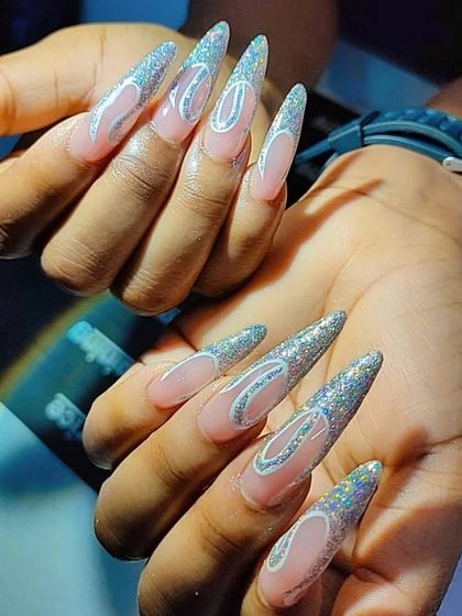 Extra-long stiletto nails with a silver glitter base and a cool Chanel logo design.