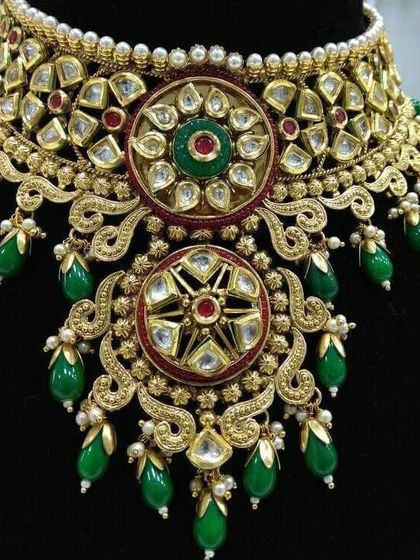 A closer look at the intricate design of this green and red Kundan choker. The floral motifs and droplet beads add a touch of royal elegance.
