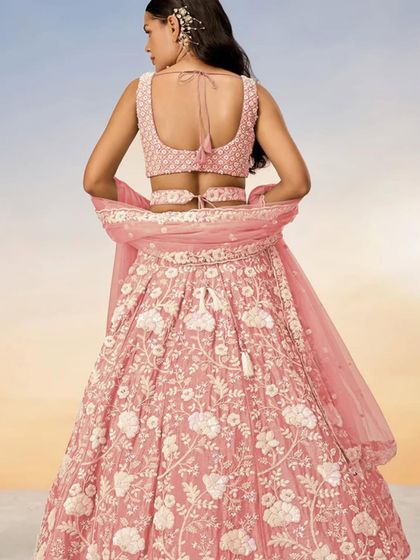 A back view of the pastel pink lehenga, highlighting the stylish blouse design.