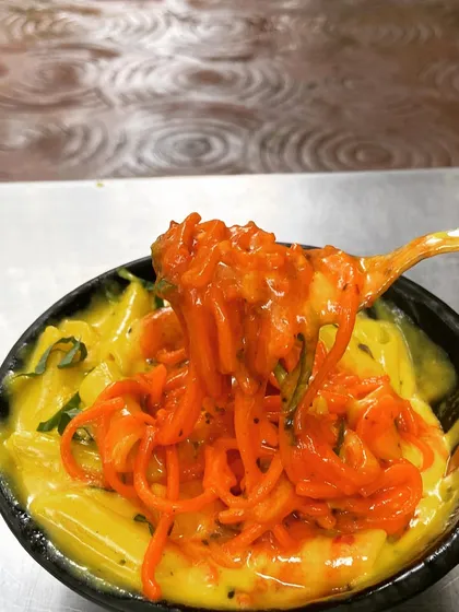 A close-up of the two distinct textures in my Pasta & Pasta dish. On one side, you have cheesy macaroni, and on the other, tangy spaghetti, creating a perfect balance.