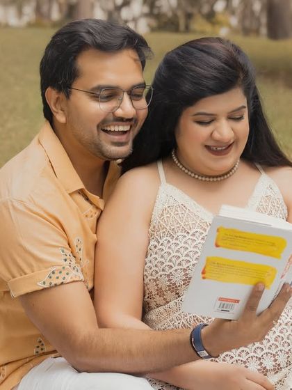 A sweet, candid moment of a couple reading a book together during their outdoor boho session. These relaxed interactions make for the most authentic and memorable photos.