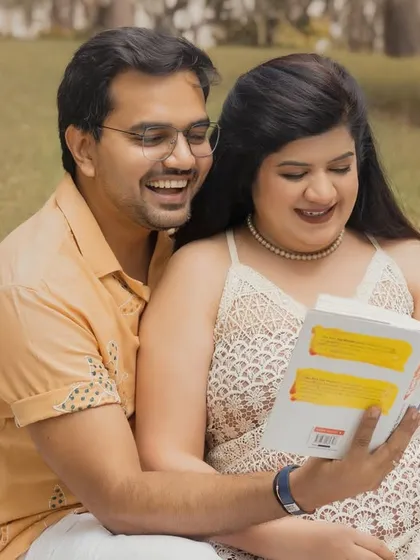A sweet, candid moment of a couple reading a book together during their outdoor boho session. These relaxed interactions make for the most authentic and memorable photos.