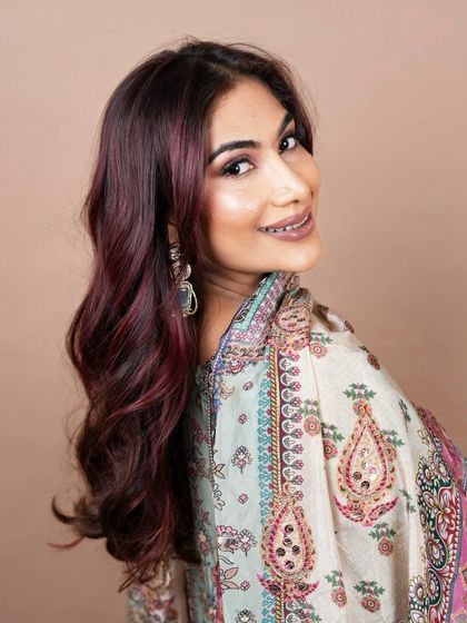A smiling portrait that captures the shine and richness of the red hair colour. Our expert colour application ensures the hair looks healthy and vibrant.