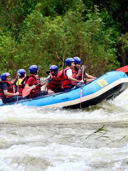 A team of adventurers charges through the white-water rapids on the Barapole River. This action shot captures the excitement and power of a monsoon rafting expedition in Coorg.