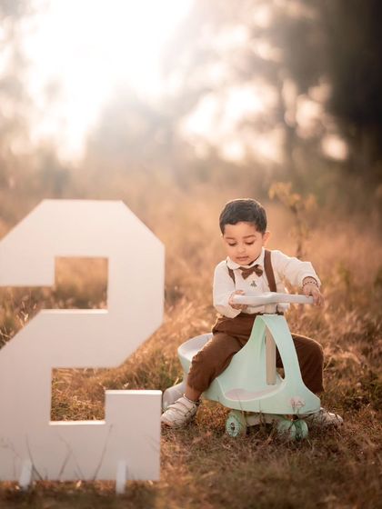 An outdoor second birthday shoot with a large number prop and a toy car. I can take the celebration outside for a different look and feel.