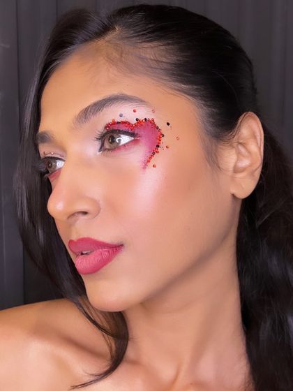 A creative and artistic look featuring a heart made of red and black gems. This is a great example of the editorial and conceptual makeup our students learn to create.