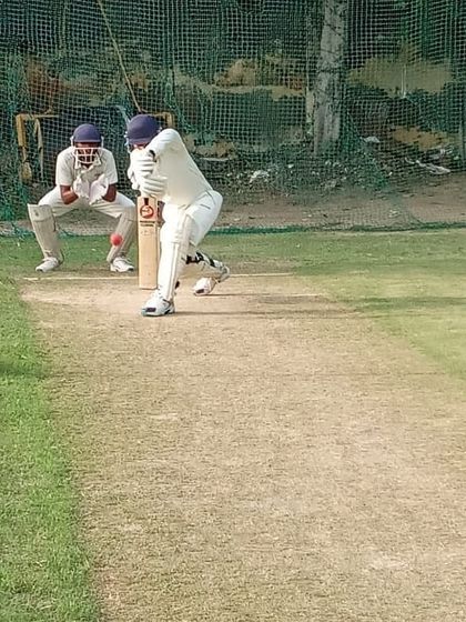 A young batsman leans into a forward drive, demonstrating excellent form and balance. Our batting drills are designed to develop a full range of scoring shots.