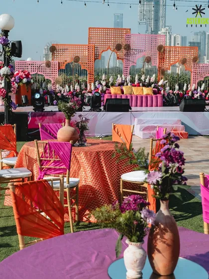 A riot of color for a beautiful Mehendi ceremony. We designed this multi-layered stage backdrop with geometric patterns and vibrant pink and orange tones, creating a picture-perfect setting against the city skyline.