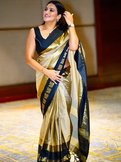 A candid, happy moment captured in this elegant gold and black saree.
