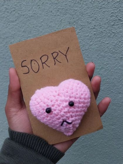 The finished crochet "sorry" card with the sad heart.