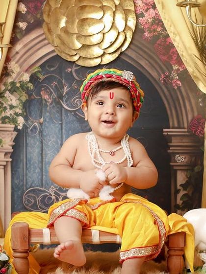 The pure joy on this little Kanha's face is priceless. The warm lighting and festive props create a happy and celebratory mood for the photoshoot.