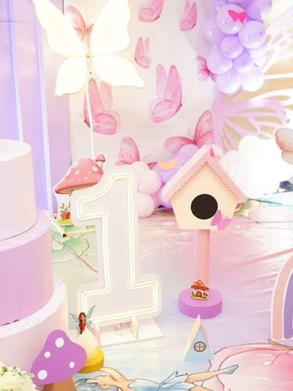 A close-up of a fairy-themed first birthday, showing the detailed props like a miniature birdhouse, a number '1' cutout, and a cute fairy character. These small touches make the theme come alive.