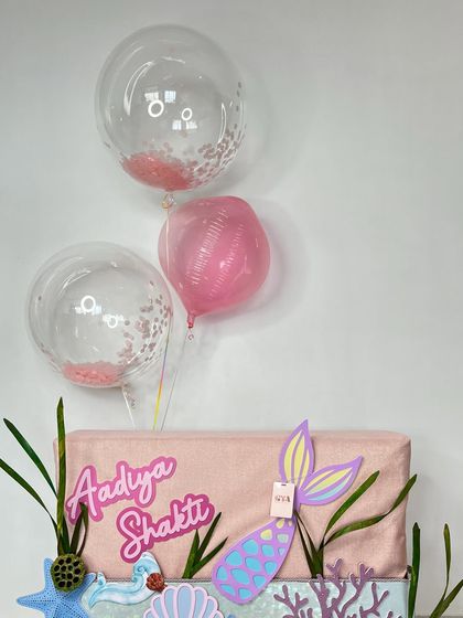 A view showing the pink confetti balloons floating above the mermaid hamper.