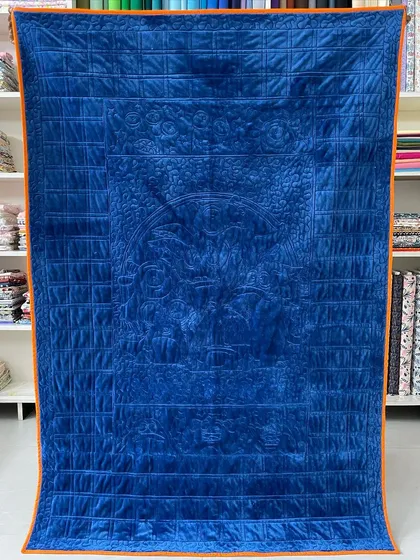 The rich blue velvet backing of the monster quilt, showing the quilting from the other side.