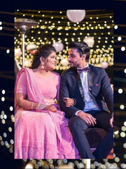 A quiet moment of connection for the couple amidst the celebration. The warm lighting adds to the romantic mood of the evening.
