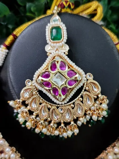 The maang tikka for this set, showcasing the same colorful stone combination.