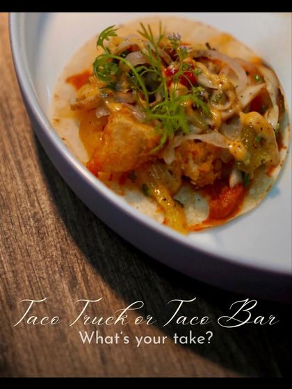 A beautifully plated taco, garnished with fresh herbs, sits on a stylish plate. This image emphasizes the gourmet quality and presentation we bring even to casual, fun food concepts like a taco bar.