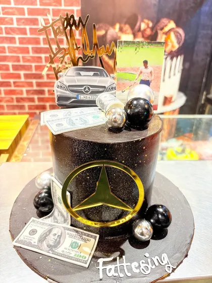 A sophisticated cake for a Mercedes-Benz fan, featuring the iconic logo, edible money, and a personal photo.