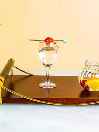 A creative shot of various cocktail glasses and a wooden serving tray. The unusual angles and colorful drinks make for a dynamic and eye-catching beverage photography composition.