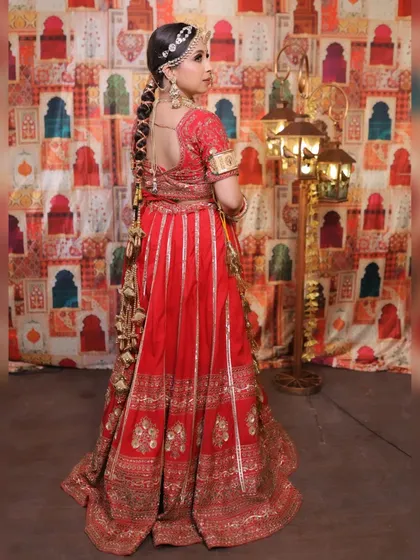 A view from the back, this image showcases the bride's intricate hairstyle, adorned with our accessories, and the detailed embroidery of her lehenga, complemented by our jewellery.