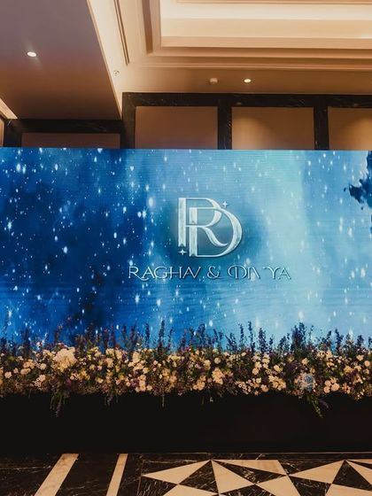 The custom LED wall featuring the couple's monogram against a galaxy-themed backdrop, serving as a stunning and personal focal point for the Sangeet.