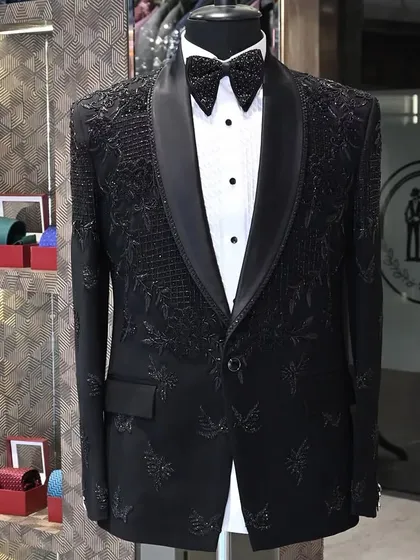 A black tuxedo designed with intricate, tonal embroidery. This style is for the man who appreciates subtle luxury, with details that reveal themselves up close.