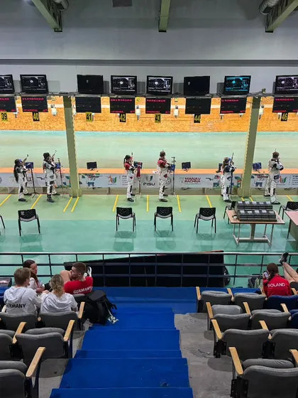 The audience watches intently during the 10M Air Rifle qualification. We create an engaging experience for spectators, making them feel part of the action.