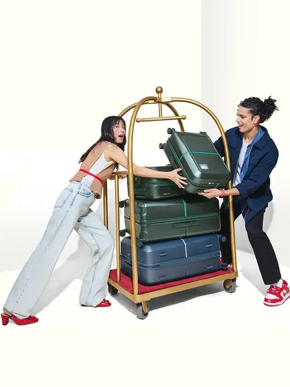 A playful and dynamic image from a luggage campaign. The models' makeup is fresh and natural, with a focus on creating a healthy, energetic glow that matches the fun-loving mood of the shoot.