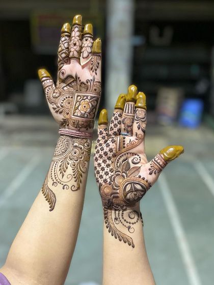 A beautiful example of asymmetrical party mehandi. Each hand has a unique floral vine design, creating a modern and artistic look.